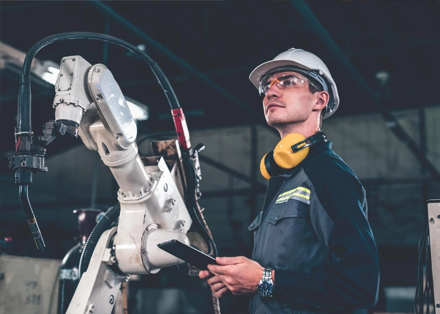 An industrial engineer wearing a helmet and overseeing production operations in a modern factory in Dubai.