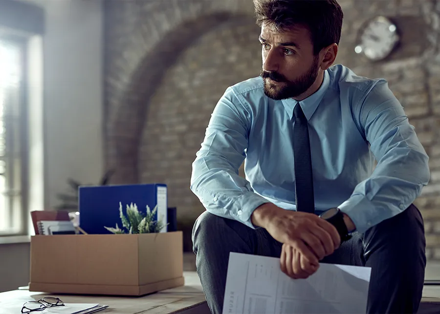 رجل أعمال يوقع على مستندات تصفية الشركة في دبي، مما يرمز إلى إنهاء الأعمال بشكل قانوني وسليم.